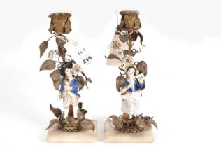 A pair of Continental figural ceramic and gilt metal candlesticks