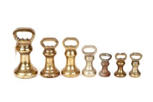 A harlequin set of antique brass bell weights
