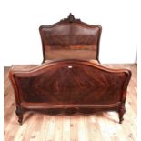 An early 20th Century rosewood double bed with arched headboard