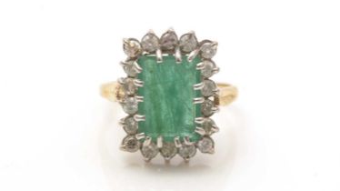 An emerald and diamond cluster ring