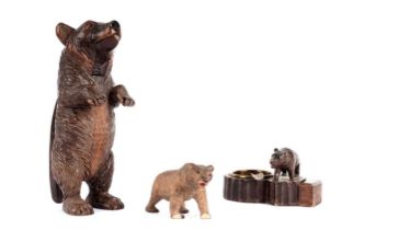 A Black Forest carved wood nutcracker; a Black Forest ashtray; and a bear figure