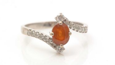An orange sapphire and diamond ring