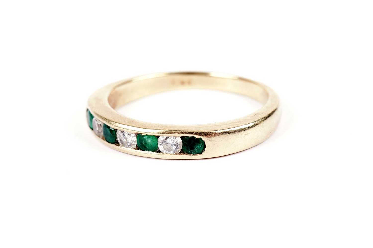 An emerald and diamond half hoop eternity ring