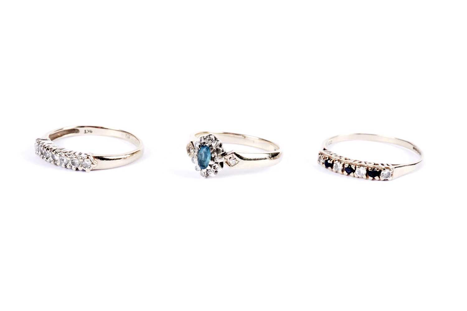 A diamond seven stone ring; and two other gold rings