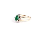An emerald and diamond swivel ring