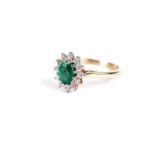 An emerald and diamond cluster ring