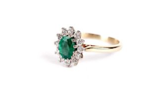 An emerald and diamond cluster ring