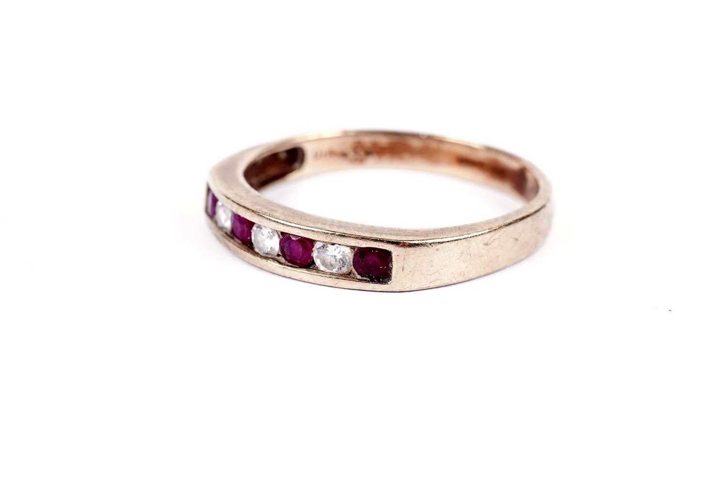 A ruby and diamond half hoop eternity ring