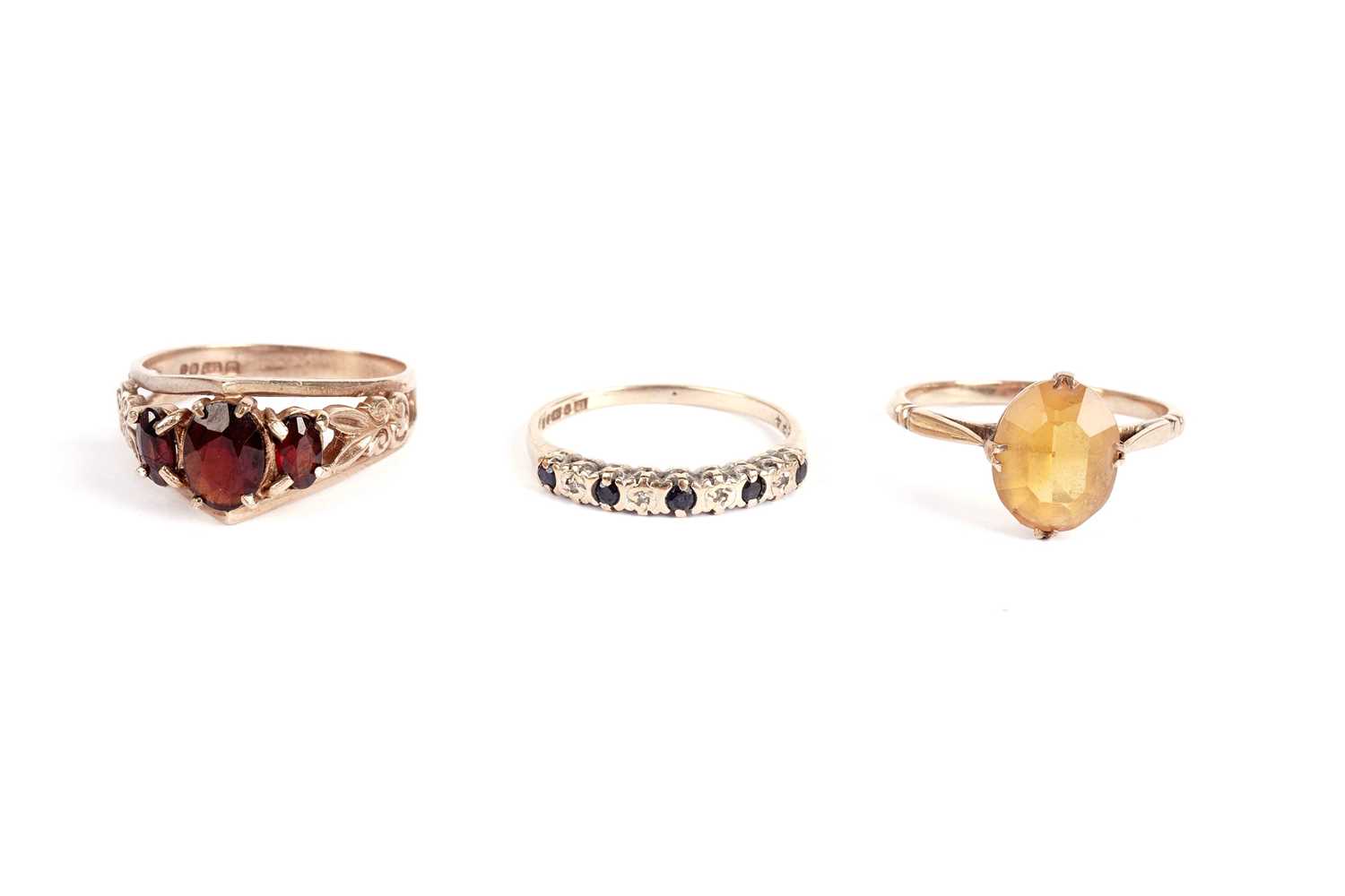 A garnet ring and two other rings