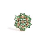 An emerald and diamond cluster ring