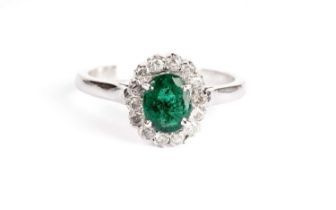 An emerald and diamond cluster ring