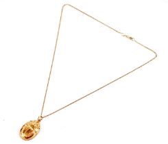A yellow gold scarab pendant on chain