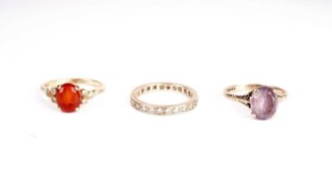 A fire opal and diamond ring; and two others