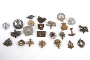 A collection of military cap badges and brooches