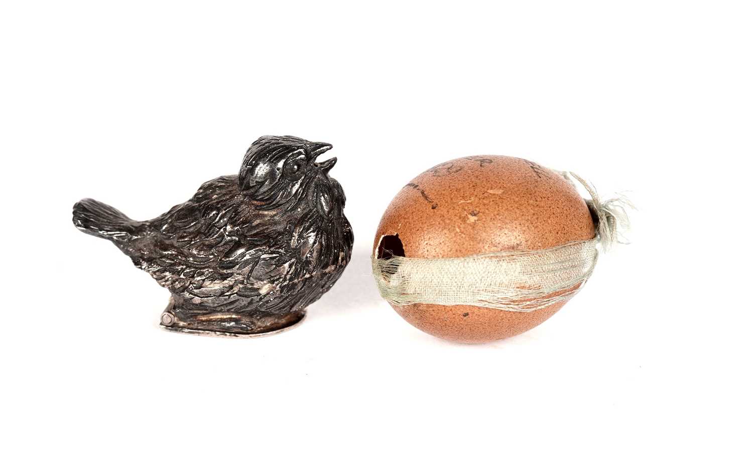 An early 20th Century bantam hen Easter egg; and a white metal chick