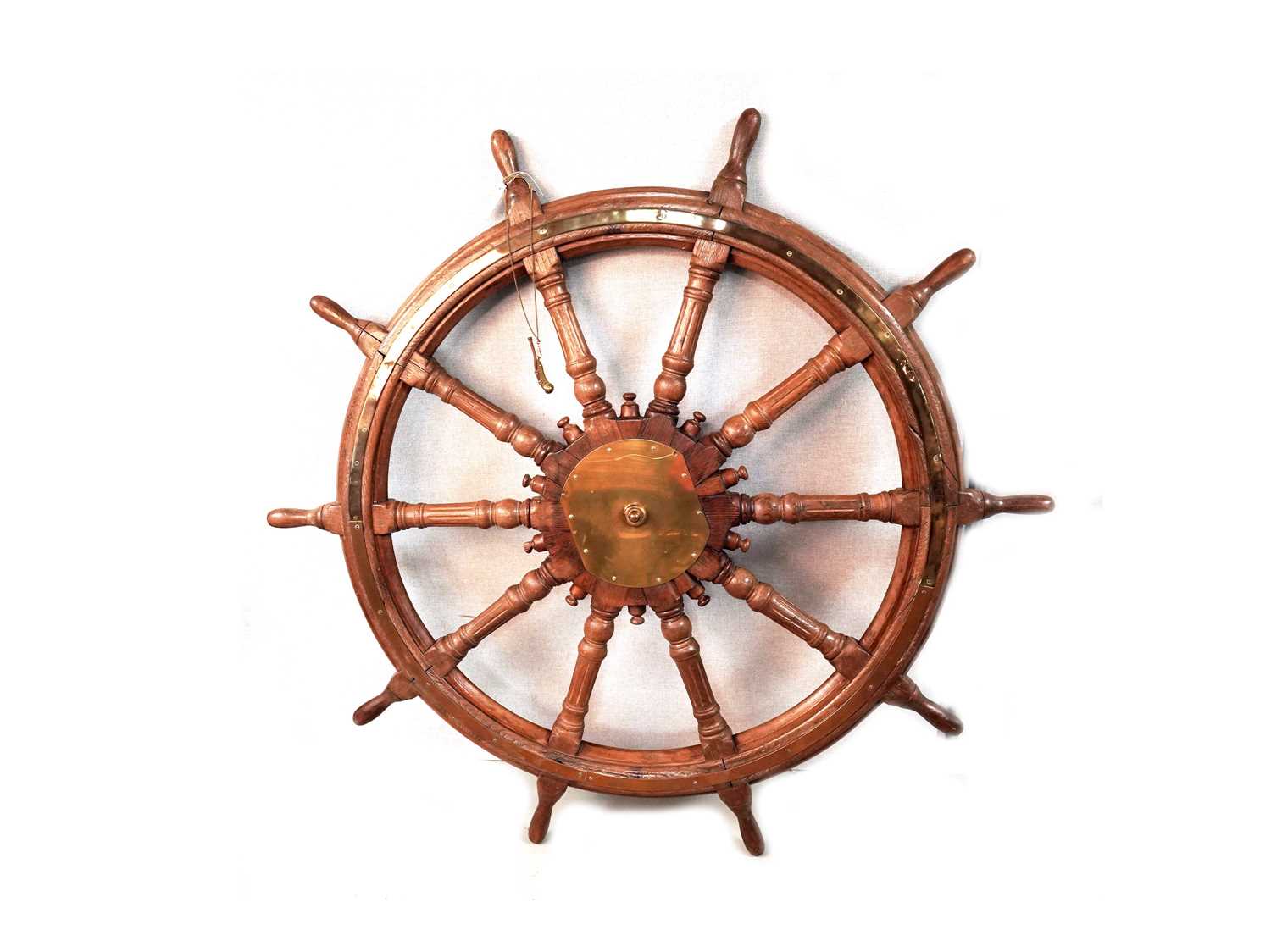 A captain's stained oak ships wheel; and a bosun's whistle