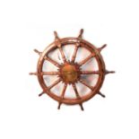 A captain's stained oak ships wheel; and a bosun's whistle