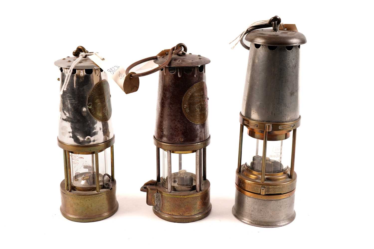 Two Eccles miners safety lamps; and another
