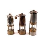 Two Eccles miners safety lamps; and another