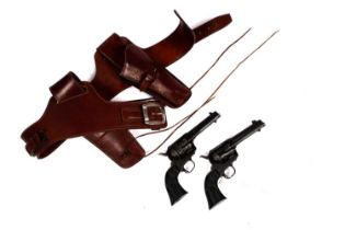 A pair of cowboy quick-draw pistols in a leather holster