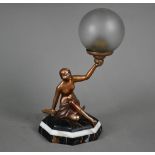 An Art Deco gold-patinated spelter figural lamp as a semi-nude female holding aloft a frosted