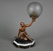 An Art Deco gold-patinated spelter figural lamp as a semi-nude female holding aloft a frosted