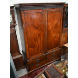 A 19th century mahogany wardrobe with moulded pediment over two doors enclosing hanging space, the
