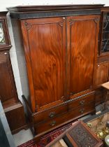 A 19th century mahogany wardrobe with moulded pediment over two doors enclosing hanging space, the