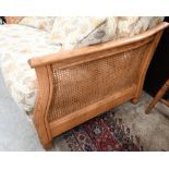 An Ercol ash and woven cane bergere three piece suite, two seater sofa and pair of armchairs,
