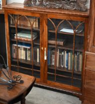 A Victorian rosewood 'piano bookcase' the pair of glazed doors enclosing three shelves standing on