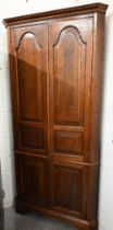 A Georgian style oak floor standing corner cabinet (one piece) with panelled cupboard doors,