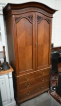 A mahogany arch-top combination wardrobe, the panelled doors enclosing pull-out hangers on chest