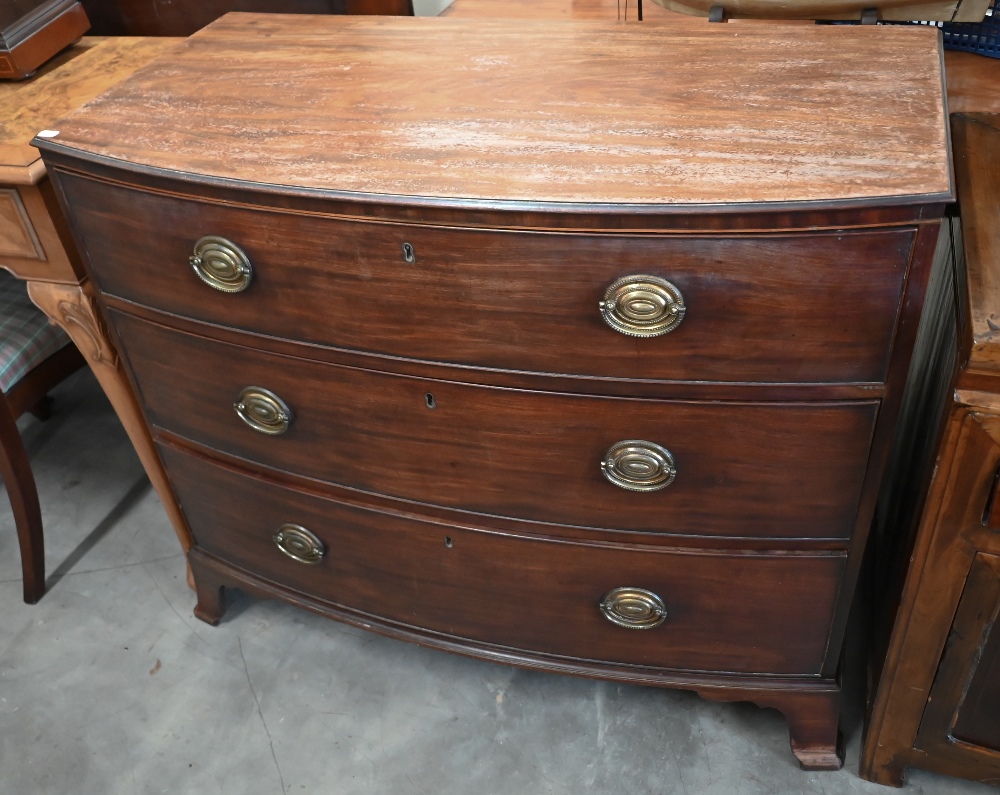 A Georgian mahogany bowfront chest of three long drawers raised on shaped bracket feet, 100 x 50 x