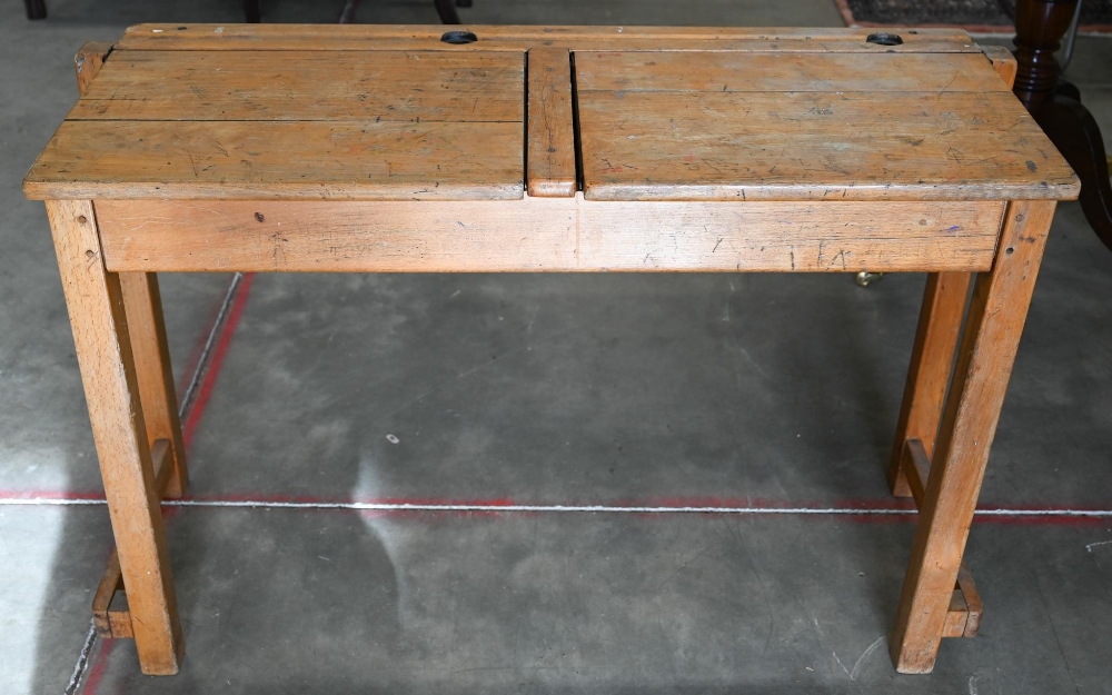 A vintage beech double school desk with twin-hinged panelled top, 108 cm wide x 40 cm deep x 66 cm