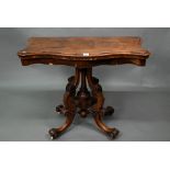 A Victorian walnut card table, the fold over serpentine top with baize lining, raise on moulded