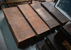 A stack of four assorted japanned steel military uniform trunks, variously labelled incl. J.