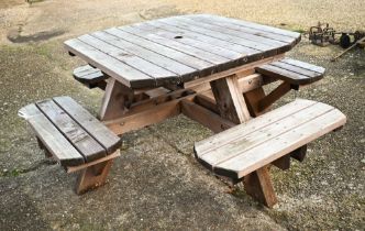 A weathered one piece wooden garden four bench seat picnic table, the table 107 cm x 107 cm x 74