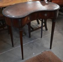 An Edwardian mahogany kidney-shaped writing table with tooled brown leather top and single frieze