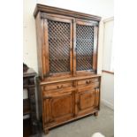 An Indian hardwood two part cabinet with open lattice panelled doors on base with two drawers and