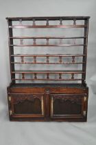 An antique provincial French oak high dresser, the three tier rack with pierced balustrades, over