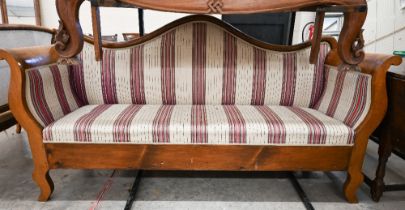 A 19th century Continental Biedermier sofa with shaped back and scroll arms upholstered with striped