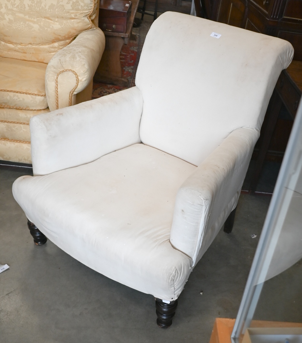 An antique oak framed low armchair with turned front legs and calico fabric cover