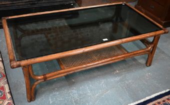 A KOK (Maison) French bamboo and rattan coffee table, with smoked glass top, 138 cm x 70 cm x 40