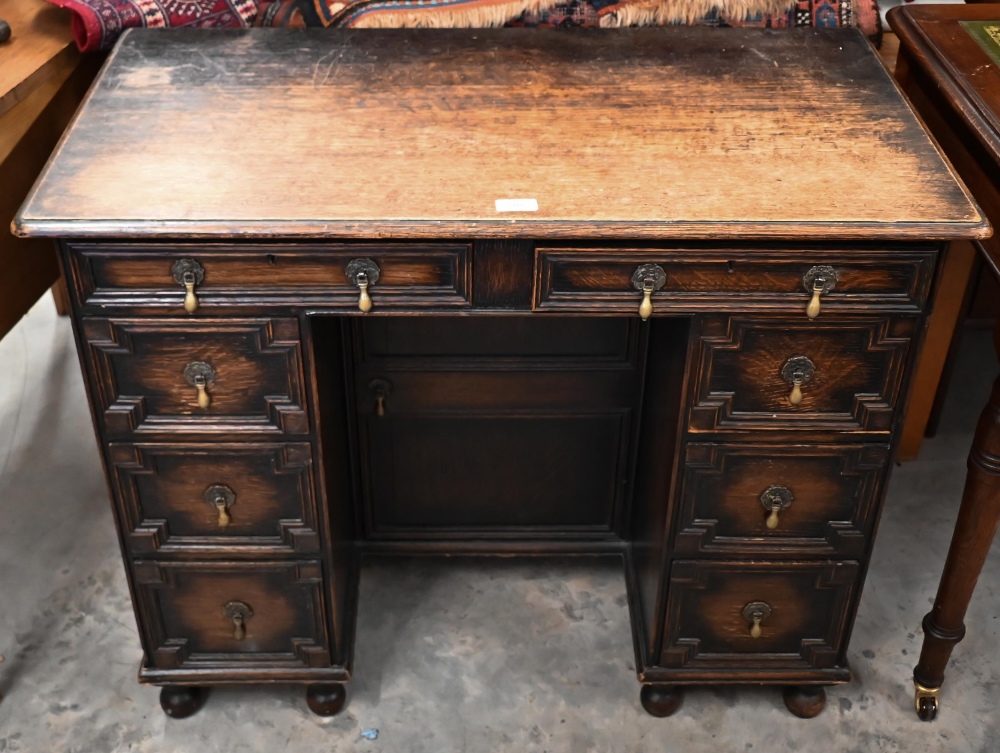 An early 20th century oak Jacobean style kneehole desk, eight drawers around central niche with - Image 3 of 4