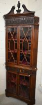 A carved mahogany floor-standing corner cabinet in two parts, with astragal glazed doors and