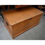 An antique pine blanket chest with hinged top and iron side handles, 98 cm wide x 52 cm deep x 46 cm