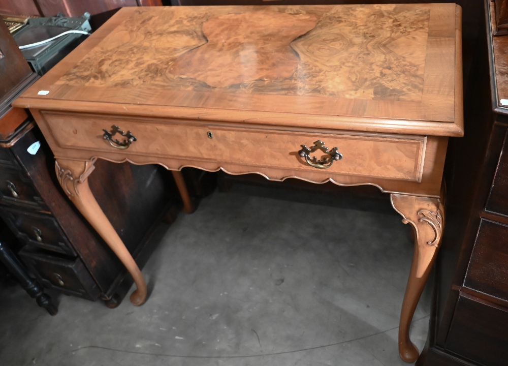A reproduction walnut side table with frieze drawer and cabriole supports with pad feet, 92 x 48 x