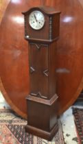 An oak cased grandmother clock with silvered dial and twin train movement c/w pendulum and key,