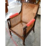 A mid 19th century mahogany framed bergere library chair with baluster turned supports and brass