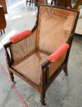 A mid 19th century mahogany framed bergere library chair with baluster turned supports and brass